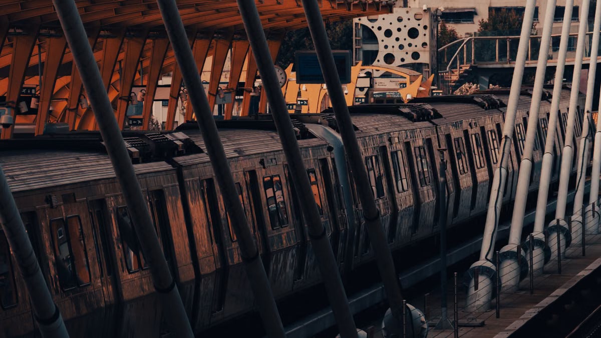 A dynamic view of a passenger train at an urban railway station with striking architecture.